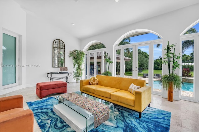 living room featuring a towering ceiling, french doors, a healthy amount of sunlight, and recessed lighting