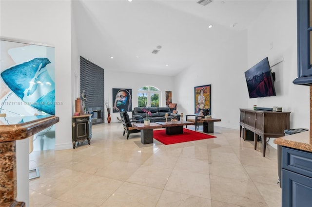 living room with a towering ceiling, a fireplace, baseboards, and recessed lighting