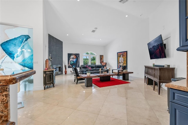 living area featuring baseboards, high vaulted ceiling, visible vents, and recessed lighting
