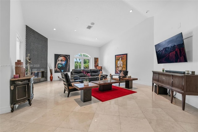 living area featuring visible vents, high vaulted ceiling, marble finish floor, and baseboards