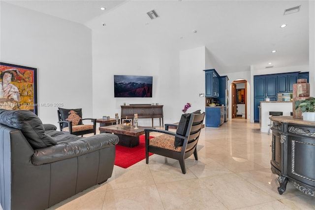 living room featuring visible vents, arched walkways, recessed lighting, and high vaulted ceiling