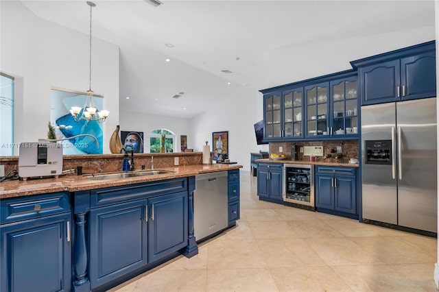 kitchen featuring stainless steel appliances, glass insert cabinets, a sink, blue cabinets, and beverage cooler