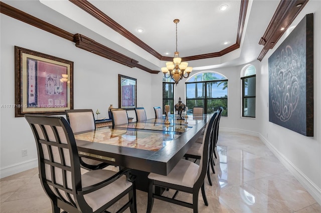 dining space with baseboards, a tray ceiling, a chandelier, and crown molding