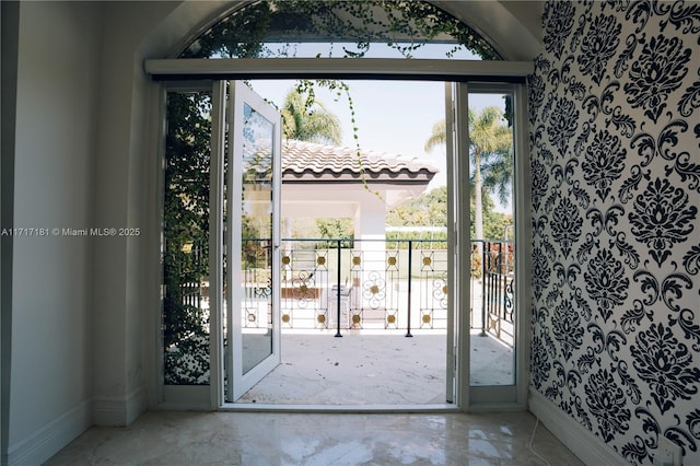 doorway featuring marble finish floor and baseboards