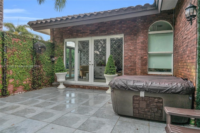 view of patio with french doors and a hot tub
