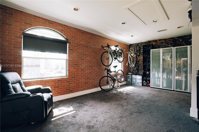 unfurnished room with dark colored carpet, brick wall, and attic access