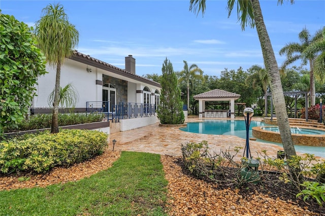 view of swimming pool with a patio, a gazebo, and a pool with connected hot tub