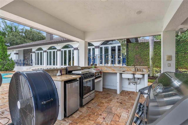 view of patio / terrace with a sink, an outdoor kitchen, a grill, and an outdoor pool