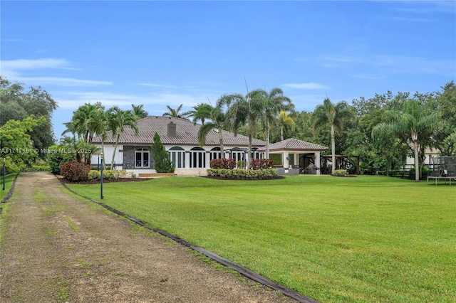 view of front of house with a front lawn, a tile roof, dirt driveway, and a gazebo