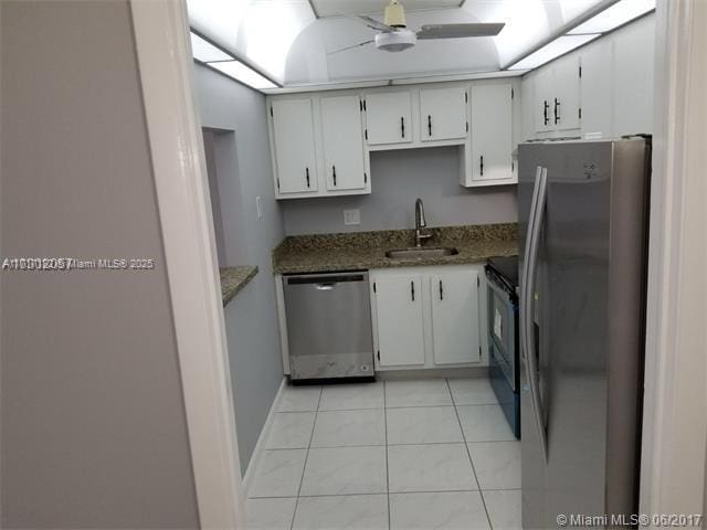 kitchen featuring sink, white cabinets, dark stone counters, and appliances with stainless steel finishes