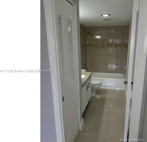 full bathroom with tile patterned flooring, vanity, toilet, and tiled shower / bath