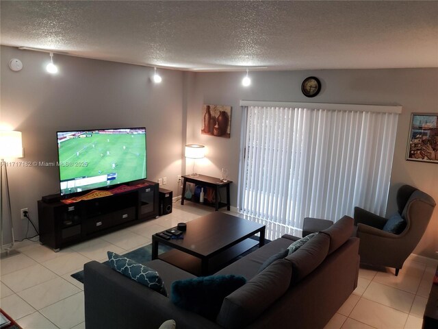 living room featuring light tile patterned floors, a textured ceiling, and rail lighting