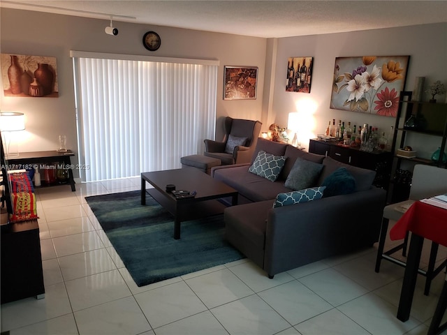 living room featuring bar area, light tile patterned floors, and rail lighting