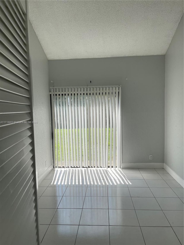 tiled spare room featuring a wealth of natural light and a textured ceiling