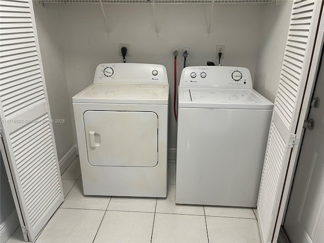 laundry room featuring washing machine and dryer and light tile patterned flooring