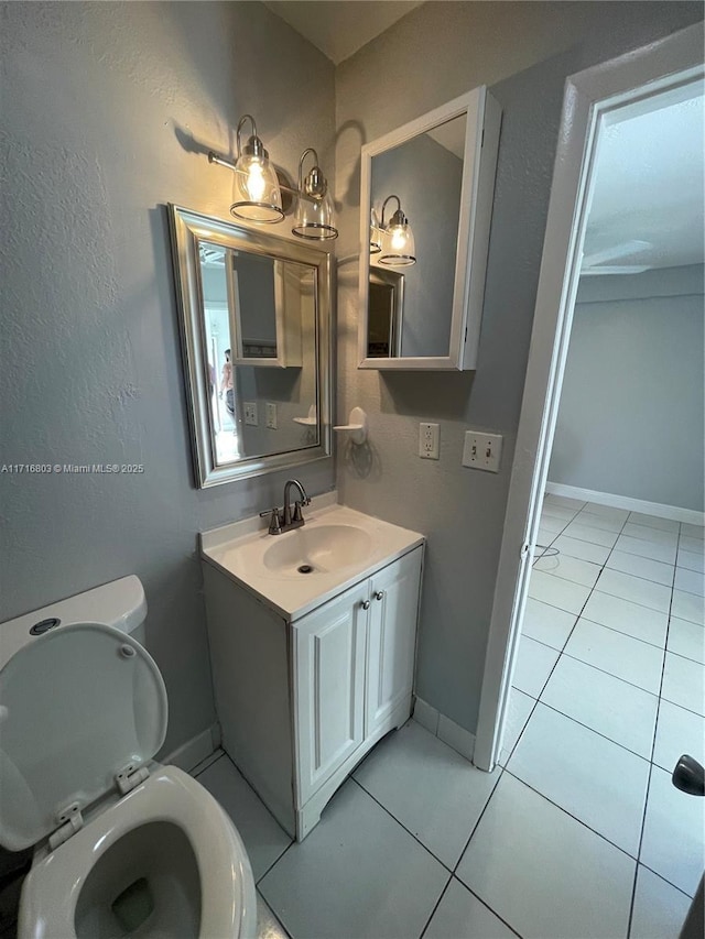 bathroom with tile patterned flooring, vanity, and toilet