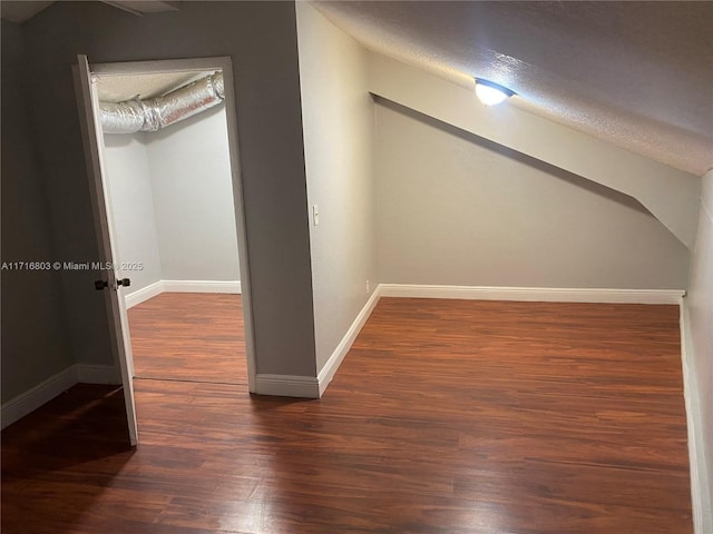 bonus room featuring a textured ceiling and dark wood-type flooring