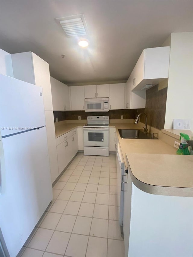 kitchen featuring tasteful backsplash, white appliances, sink, white cabinetry, and light tile patterned flooring