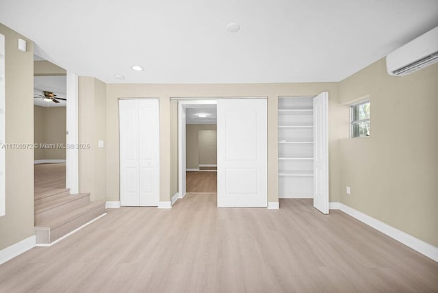 unfurnished bedroom featuring light hardwood / wood-style floors and a wall mounted AC