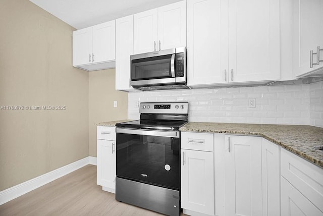 kitchen featuring light stone countertops, white cabinets, light hardwood / wood-style floors, and appliances with stainless steel finishes