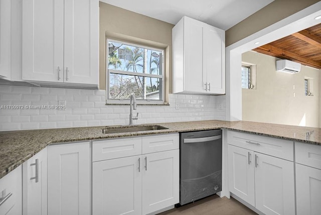 kitchen with stainless steel dishwasher, decorative backsplash, light stone counters, and white cabinetry