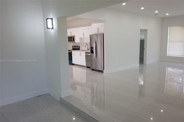 interior space featuring white cabinets, sink, and stainless steel appliances