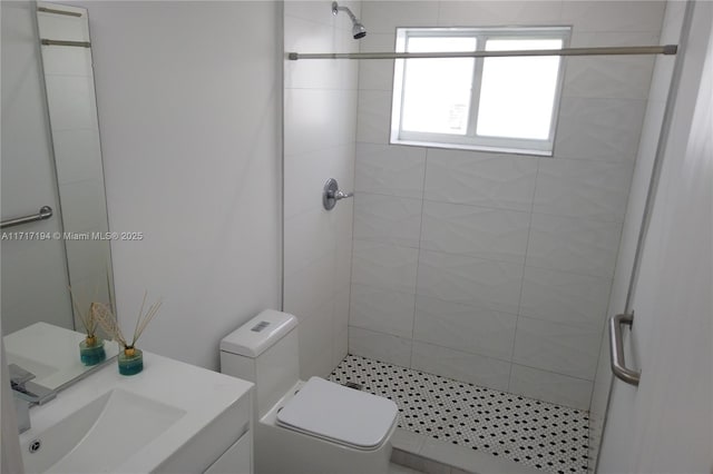 bathroom featuring a tile shower, vanity, and toilet