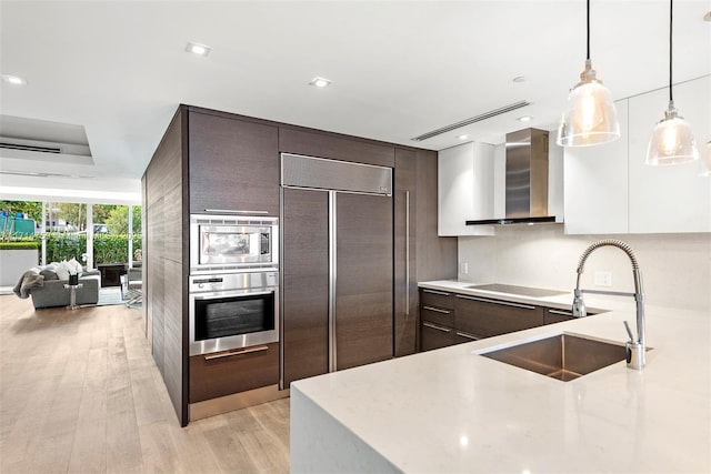 400 Alton Rd Unit 509, Miami Beach, FL 33139 - kitchen with built in appliances, wall chimney exhaust hood, modern cabinets, dark brown cabinets, and recessed lighting