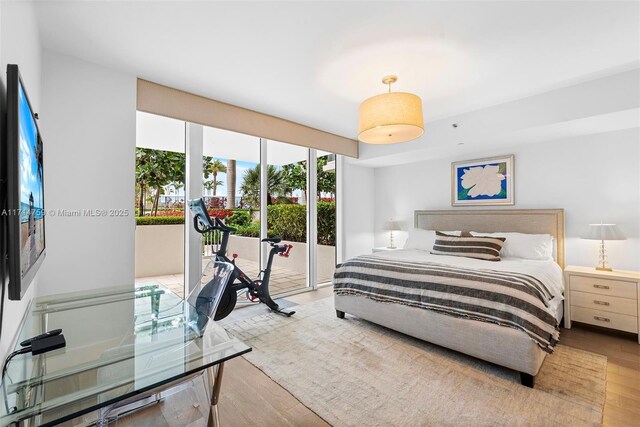 bedroom featuring access to exterior and light hardwood / wood-style flooring