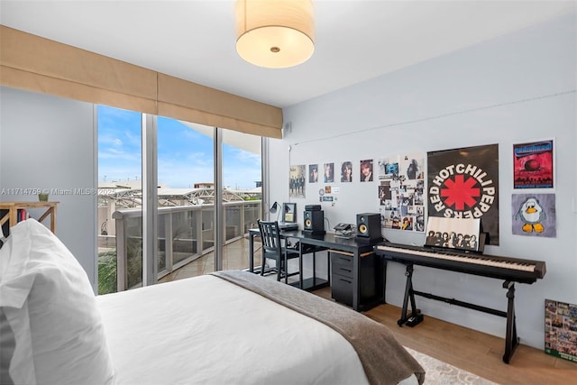 bedroom featuring access to exterior and wood-type flooring