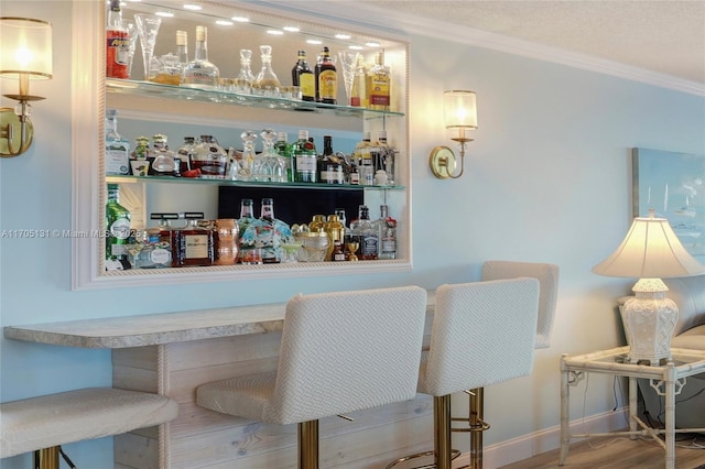 bar with crown molding and light wood-type flooring