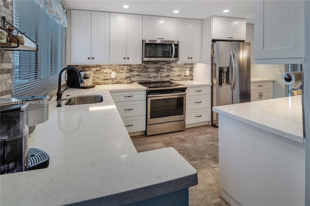 kitchen featuring decorative backsplash, sink, white cabinets, and stainless steel appliances