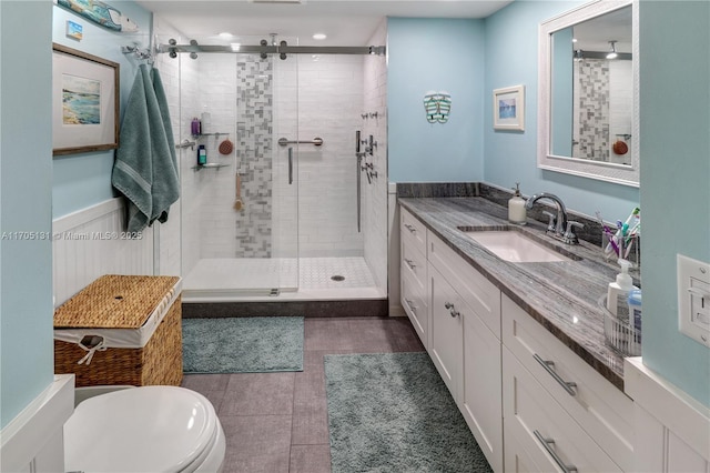 bathroom featuring tile patterned flooring, vanity, toilet, and a shower with door