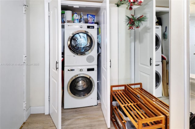 clothes washing area featuring light hardwood / wood-style floors and stacked washer and dryer