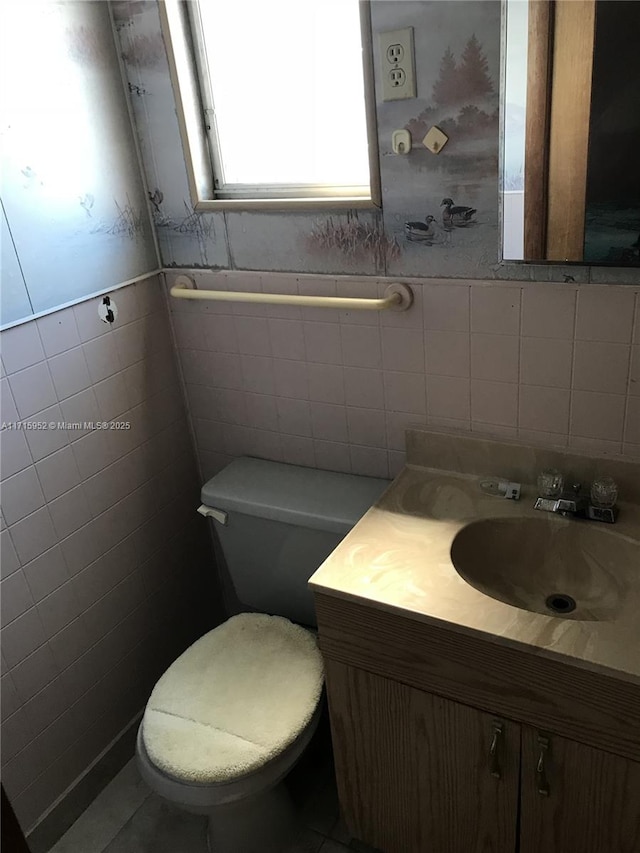 bathroom featuring vanity, toilet, and tile walls