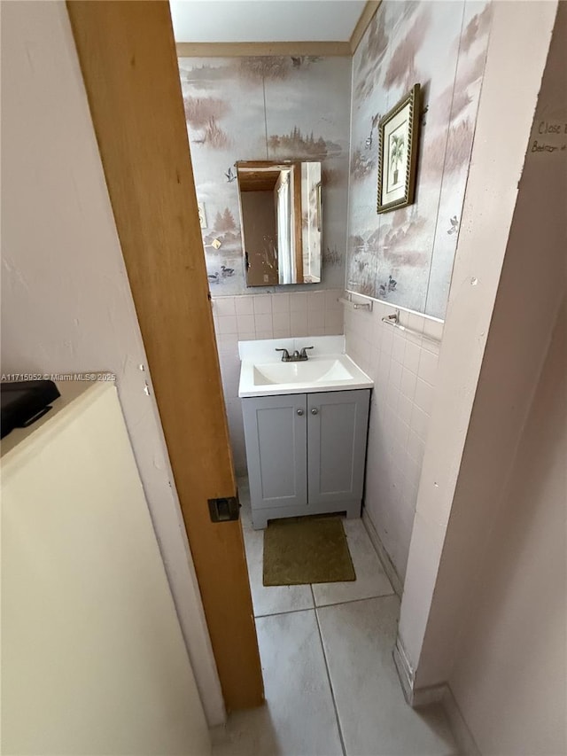 bathroom with tile patterned flooring, vanity, and tile walls