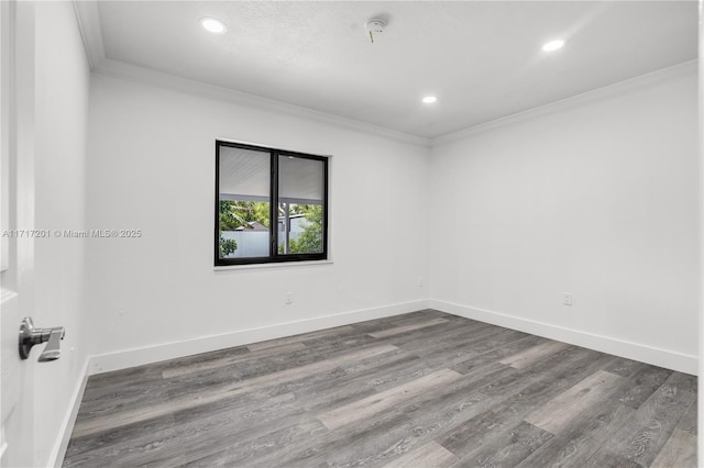 spare room with crown molding and hardwood / wood-style floors