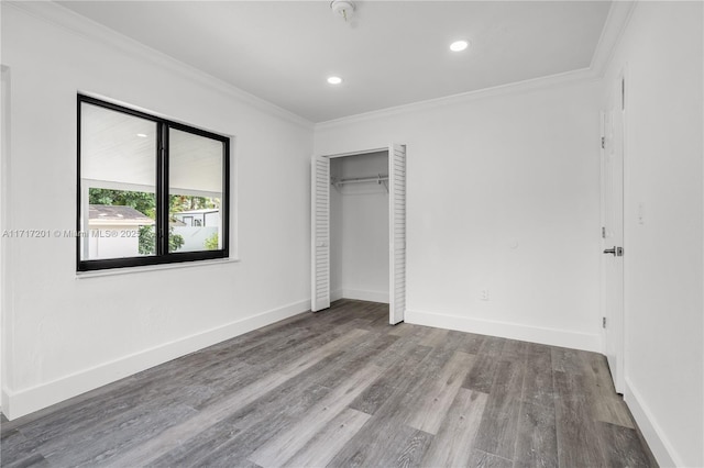 unfurnished bedroom with hardwood / wood-style flooring, a closet, and ornamental molding