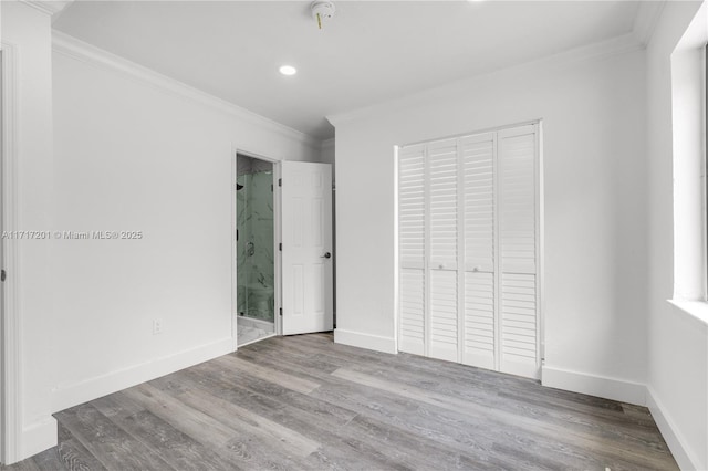 unfurnished bedroom with hardwood / wood-style floors, a closet, and ornamental molding