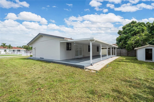 rear view of property featuring a patio area and a yard