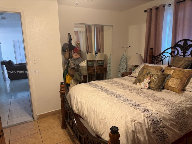 bedroom with a closet, baseboards, and light tile patterned floors