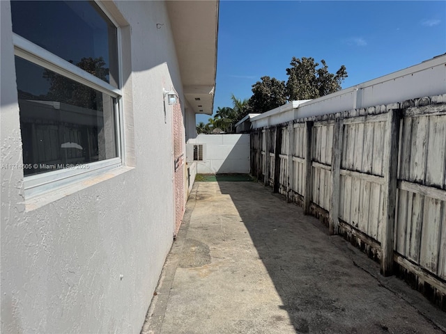 view of side of property featuring fence and stucco siding