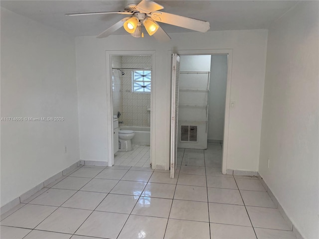 interior space featuring ceiling fan, light tile patterned flooring, visible vents, and baseboards