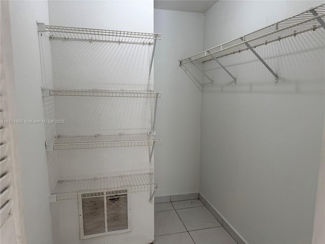 spacious closet with light tile patterned floors