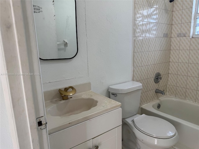 bathroom with toilet, a textured wall, shower / bathing tub combination, and vanity