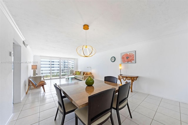 tiled dining area featuring a textured ceiling, an inviting chandelier, a wall of windows, and crown molding