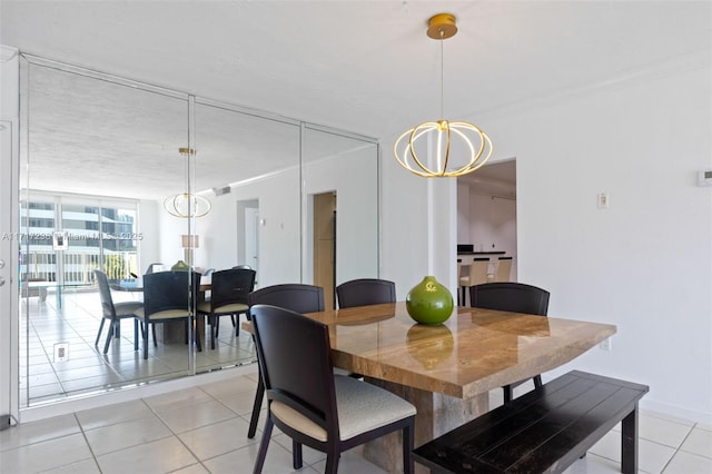 tiled dining area with crown molding and an inviting chandelier