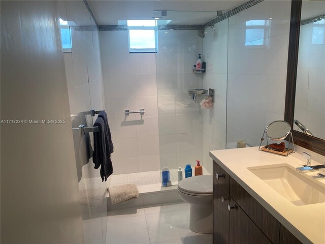 bathroom with toilet, vanity, and tile patterned floors