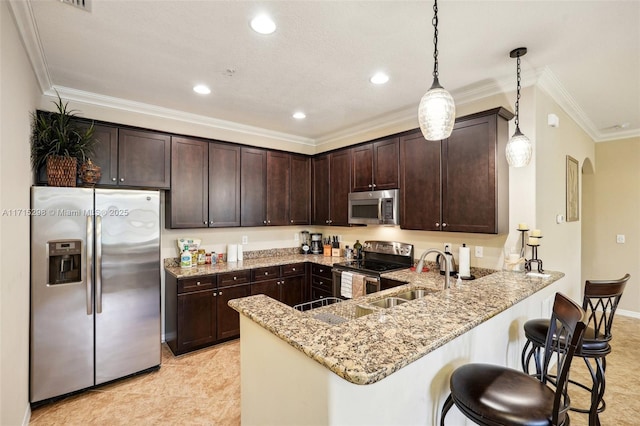 kitchen with kitchen peninsula, appliances with stainless steel finishes, dark brown cabinetry, sink, and pendant lighting