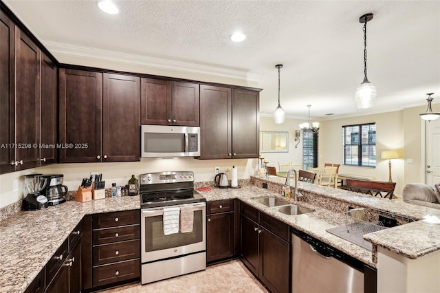 kitchen featuring appliances with stainless steel finishes, sink, decorative light fixtures, kitchen peninsula, and ornamental molding